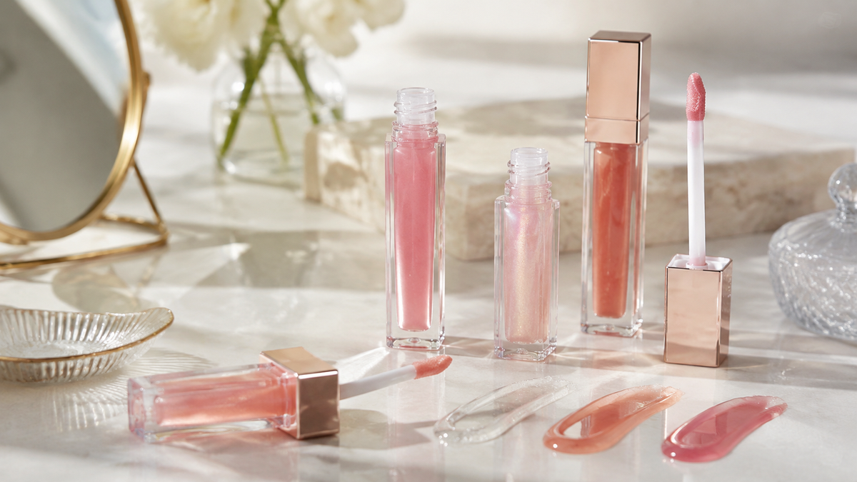 Generic lip oil tubes and glossy swatches on a vanity